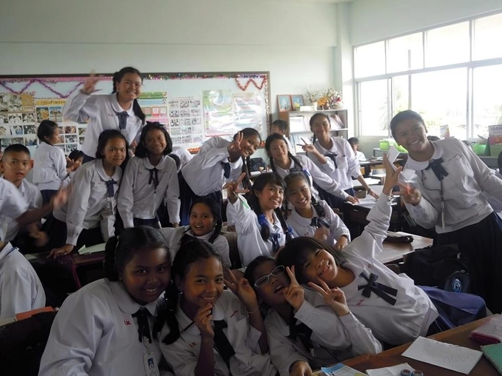 children posing with smiles in a classroom