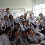 children posing with smiles in a classroom