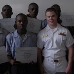 naval officer with class holding certificates