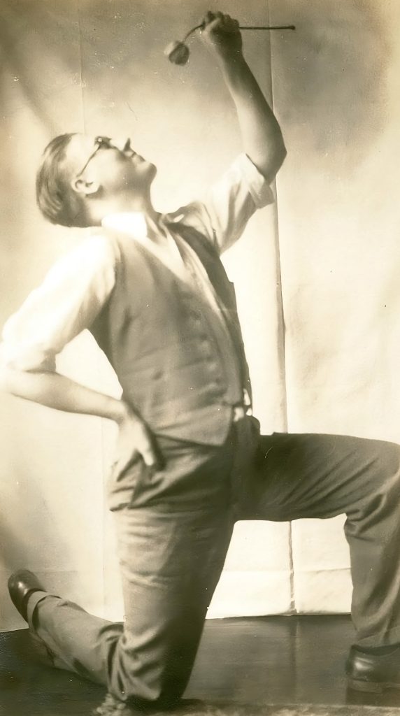 Harry Hoijer kneeling holding a flower