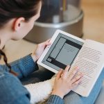 person reading a book on a tablet