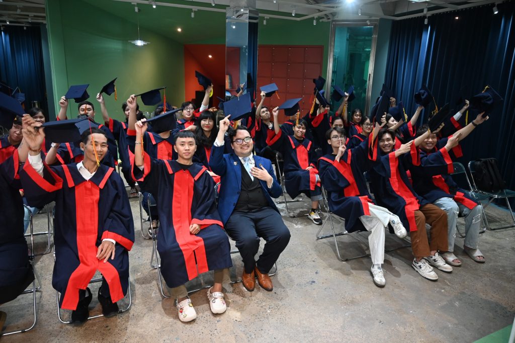 class of american tesol graduates raising their arms.